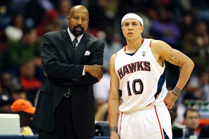 Atlanta Hawks coach Mike Woodson talks guard Mike Bibby (10) during a free throw against the Milwaukee Bucks with during the second half at Phillips Arena. The Hawks defeated the Bucks 106-102 in Overtime.